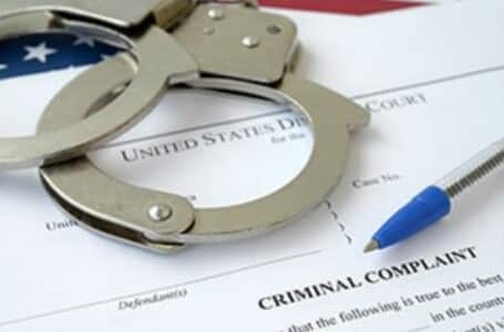 Handcuffs on top of a criminal complaint.