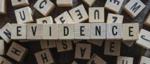 The word "EVIDENCE" spelled out using scrabble tiles.