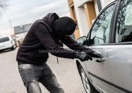 A man breaking into a car.