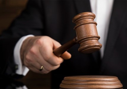 A judges hand holding a gavel.