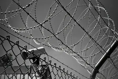 Barbed wire and a security camera at a prison.