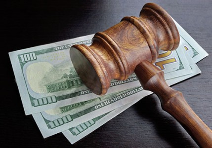 A wooden gavel on top of $100 bills.