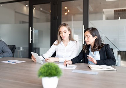 Two female attorneys working together in a shared workspace setting.