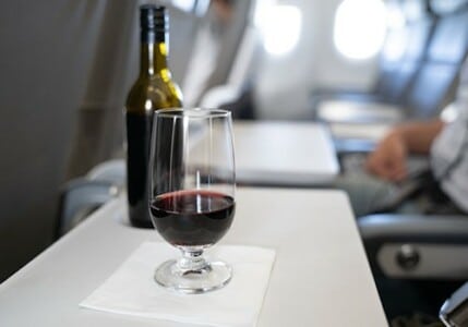 Glass of wine on a plane's tray table.