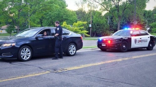 A driver pulled over by the police receiving a red light ticket.
