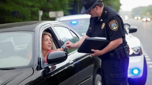 A police officer getting a driver's license from a driver he stopped for speeding.