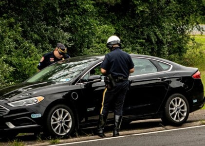 A motorist being spoken to by the police about driving barefoot.