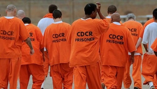 Prisoners in orange jumpsuits.