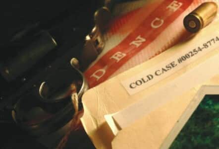 A cold case folder with a gun and bullet evidence.