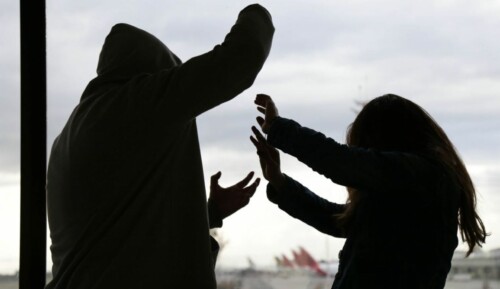 A silhouette of a man and woman where the woman is being assaulted.